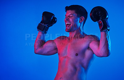 Buy stock photo Blue filtered shot of a sportsman wearing boxing gloves while posing in the studio
