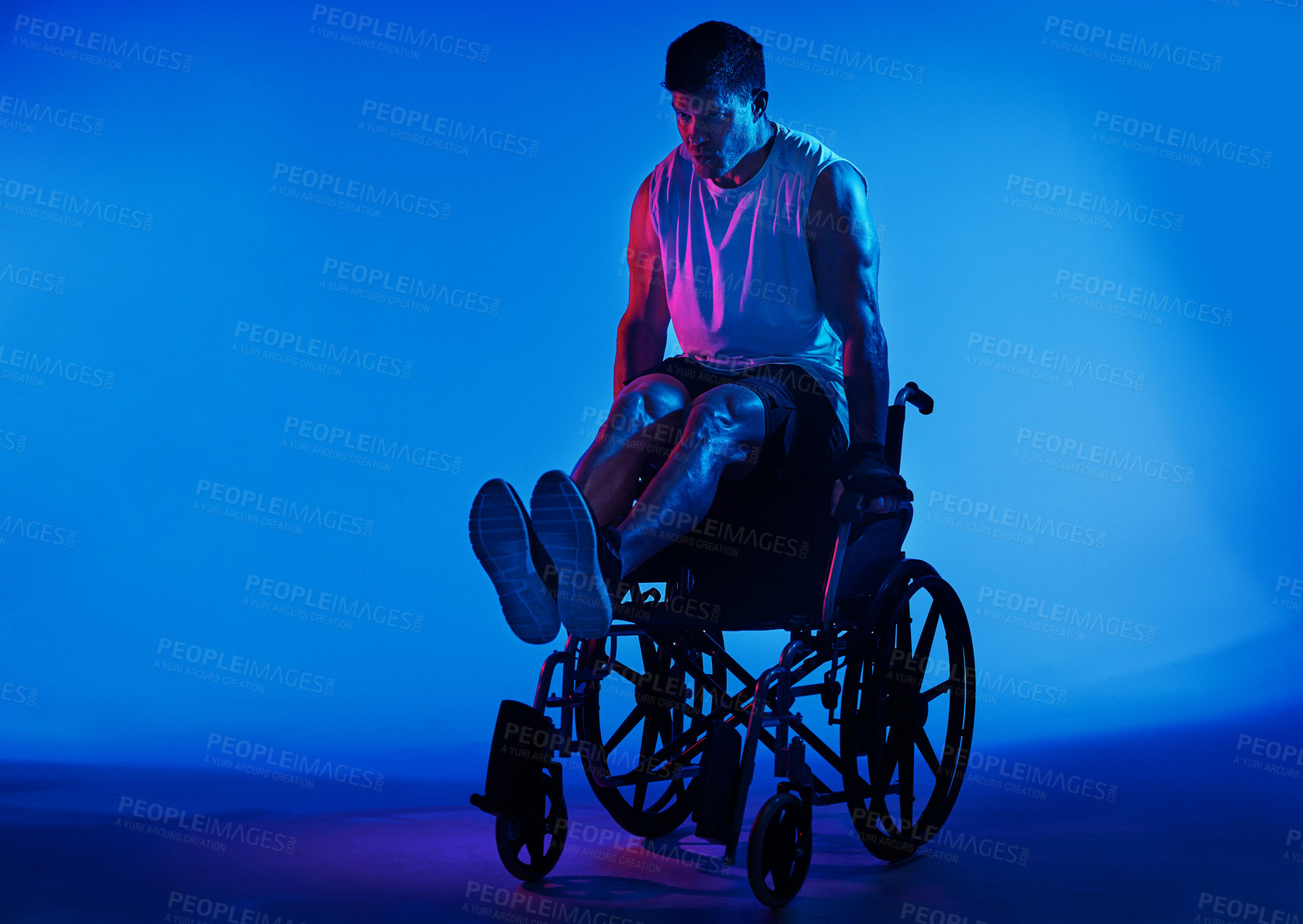 Buy stock photo Blue filtered shot of a man exercising while sitting in his wheelchair