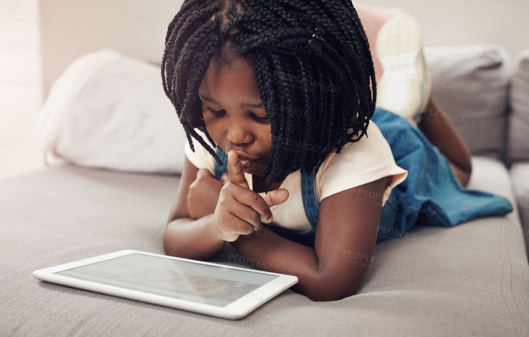 Buy stock photo Cropped shot of an adorable little girl having fun while using a digital tablet at home