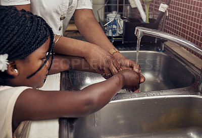 Buy stock photo Hands, kitchen sink and mom with kid, teaching or help to wash with soap, water or clean to stop germs. African family home, mother and daughter at tap for cleaning, helping hand or wellness in house