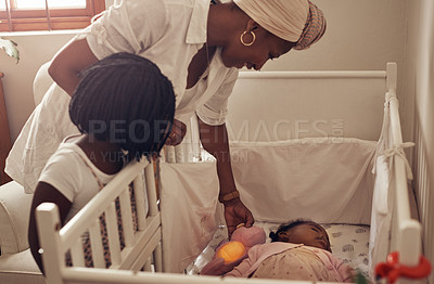 Buy stock photo Cropped shot of an adorable little girl and her mother watching her baby sister sleeping in her crib at home