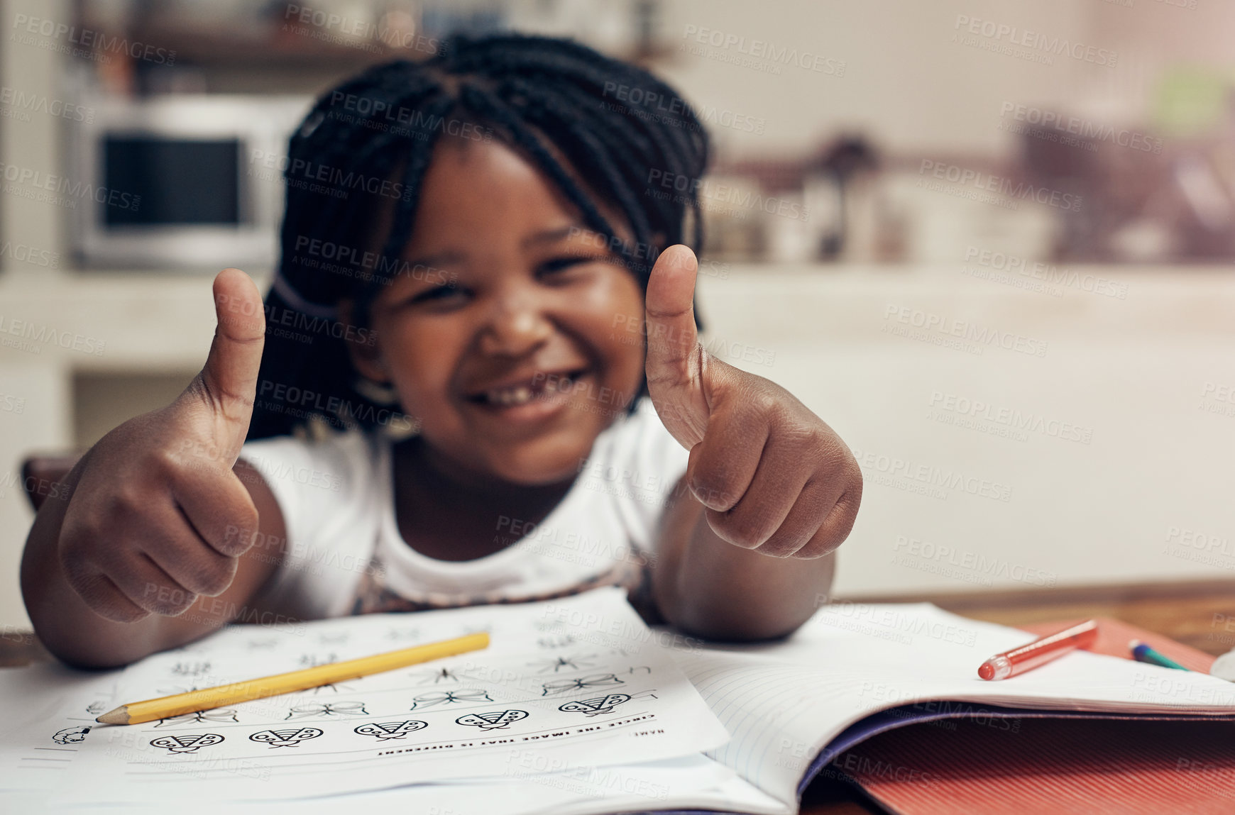 Buy stock photo Portrait of an adorable little girl posing with her thumbs up while doing her homework at home