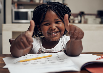 Buy stock photo Portrait of an adorable little girl posing with her thumbs up while doing her homework at home