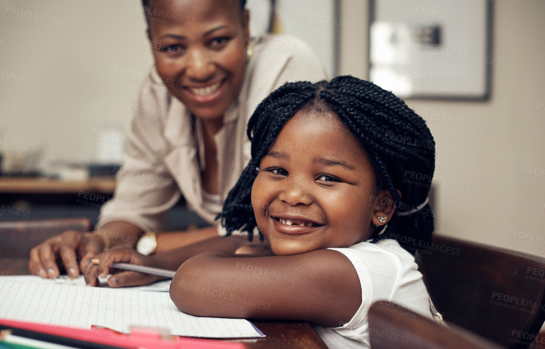 Buy stock photo Portrait of an adorable little girl smiling while doing her homework with her mother at home