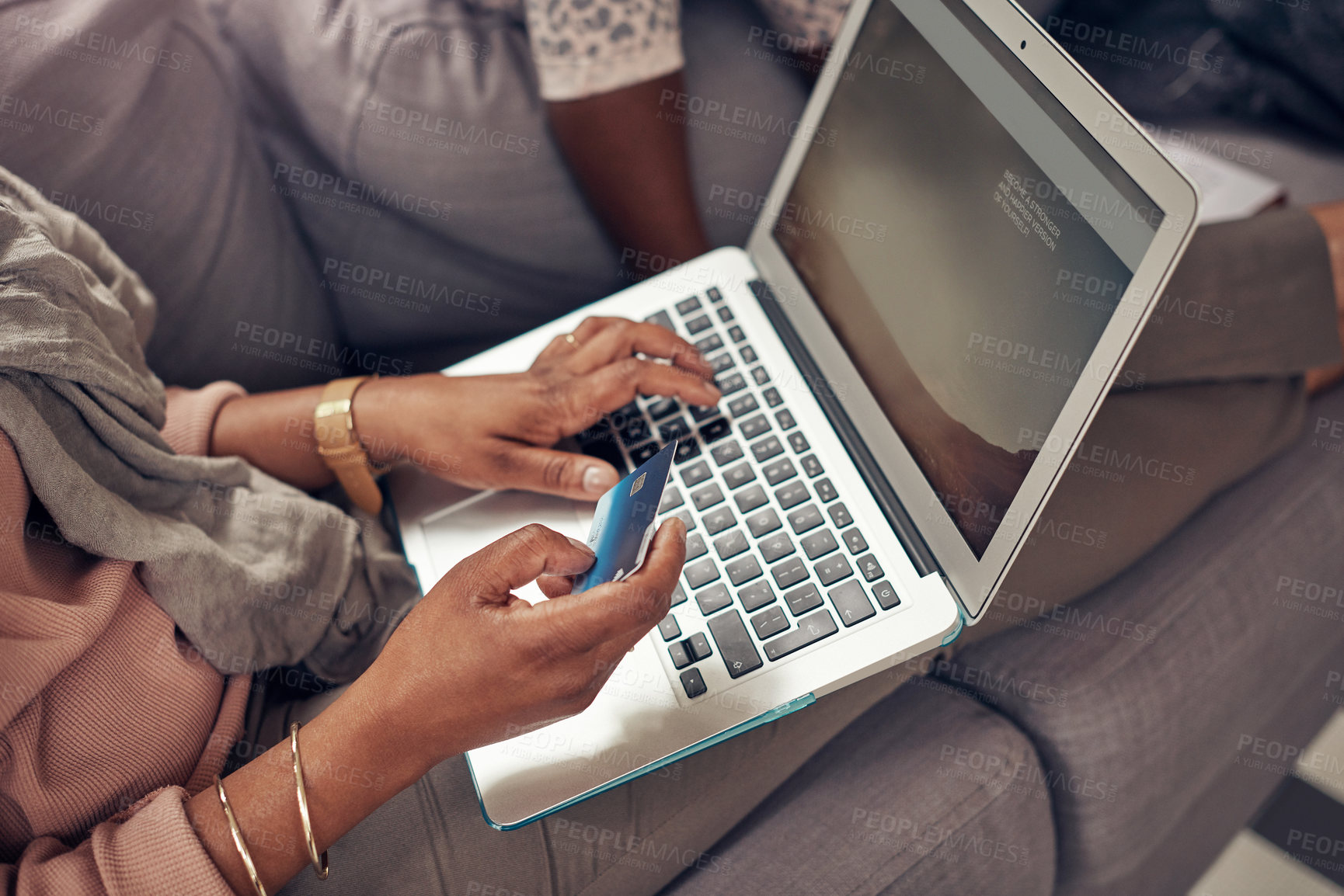 Buy stock photo Cropped shot of an unrecognizable woman using her credit card and laptop while relaxing with her daughter at home