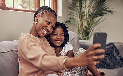 Buy stock photo Cropped shot of an adorable mother and daughter taking selfies together at home