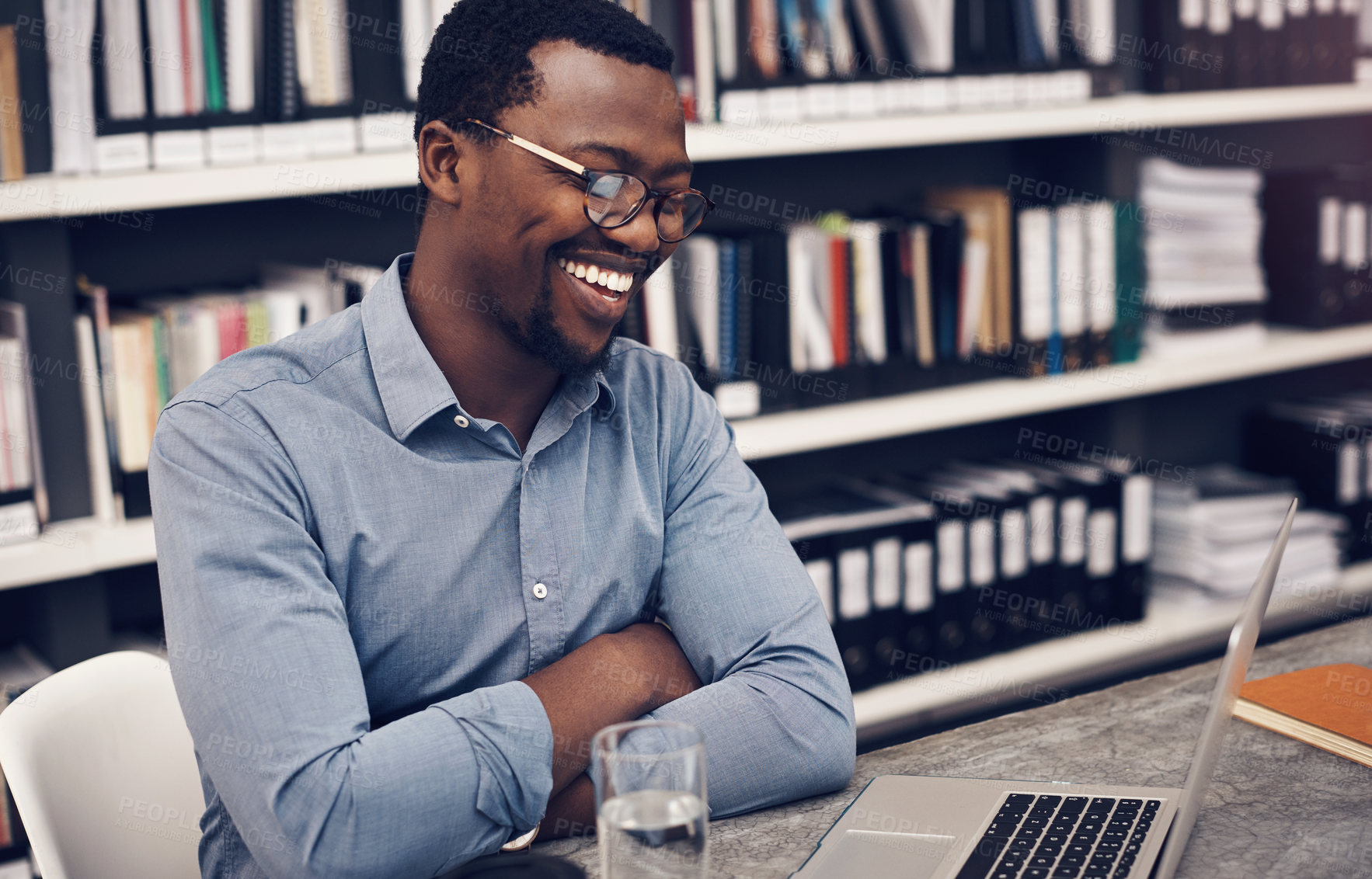 Buy stock photo Cropped shot of a handsome young male architect smiling while working on a laptop in a modern office