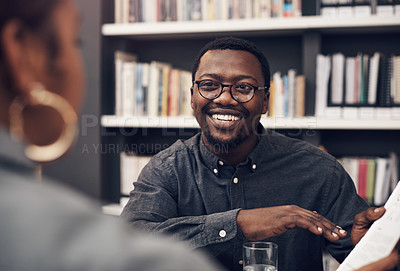 Buy stock photo Cropped shot of a handsome young male architect having a discussion with his colleague in a modern office