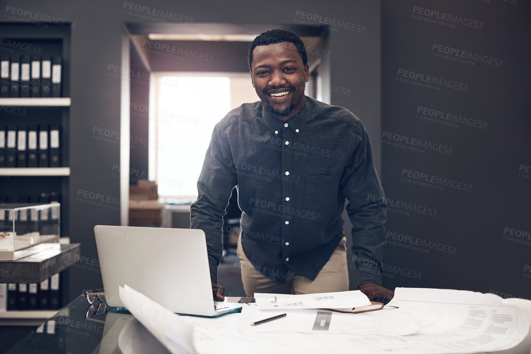 Buy stock photo Smile, portrait and black man with blueprint in office for project development, progress and review. Contractor, happy and architect with laptop by paper for floor plan, research and building design