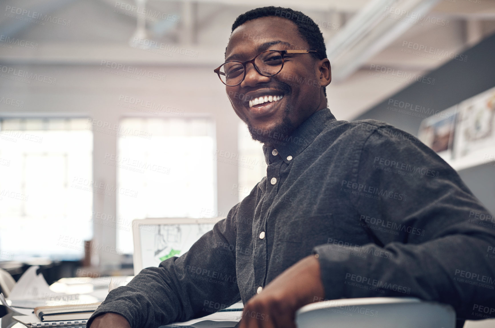 Buy stock photo Cropped portrait of a handsome young male architect smiling while sitting in a modern office