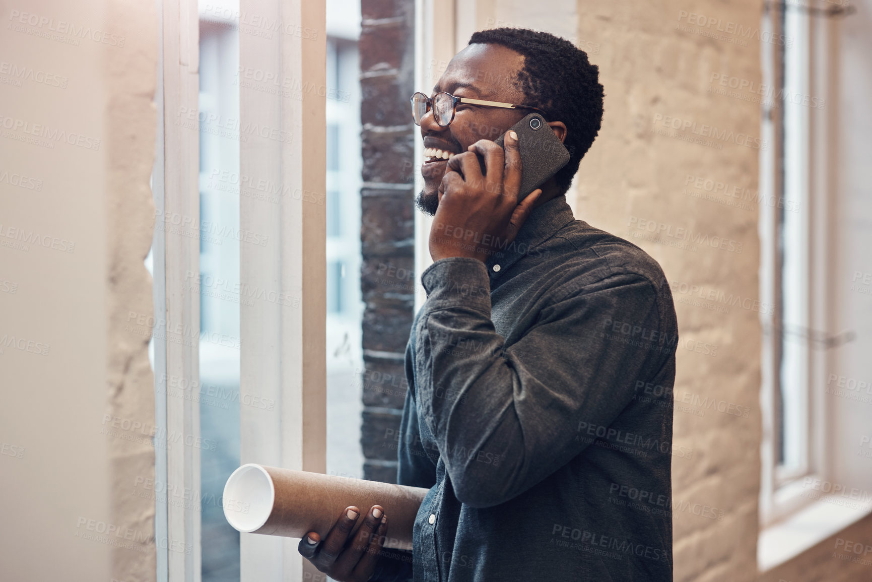 Buy stock photo Happy, black man and phone call with blueprint in office for architecture, communication or feedback. Contractor, smile and employee with tech at work for floor plan, conversation or update to client