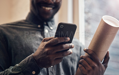 Buy stock photo Cropped shot of an unrecognizable male architect using a smartphone while standing in a modern office