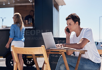 Buy stock photo Cropped shot of a cheerful young woman talking on her cellphone while doing work on her laptop next to a beach promenade outside during the day