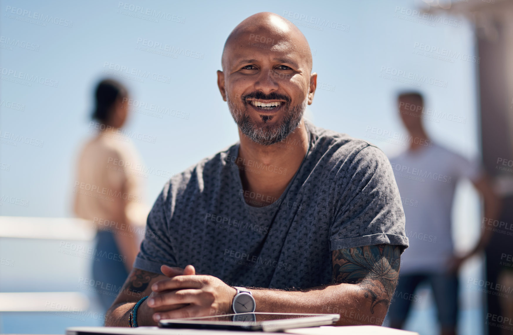 Buy stock photo Portrait of a cheerful middle aged man seated at a table outside next a beach promenade