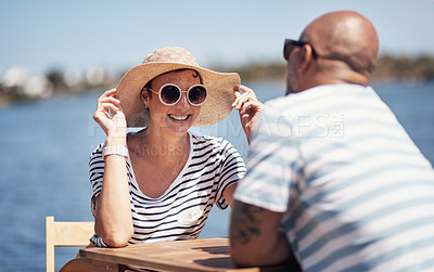 Buy stock photo Cropped shot of a cheerful young couple having a lunch date outside next to a beach promenade