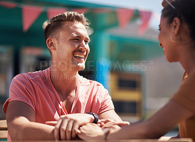 Buy stock photo Cropped shot of a cheerful young couple having a lunch date outside next to a beach promenade