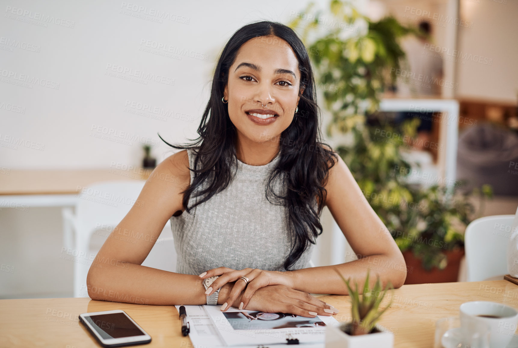 Buy stock photo Portrait of a young businesswoman sitting at a desk in an office