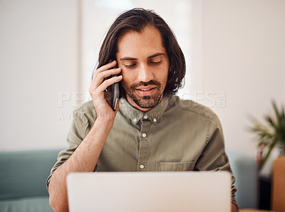 Buy stock photo Shot of a young businessman talking on a cellphone while using a laptop in an office