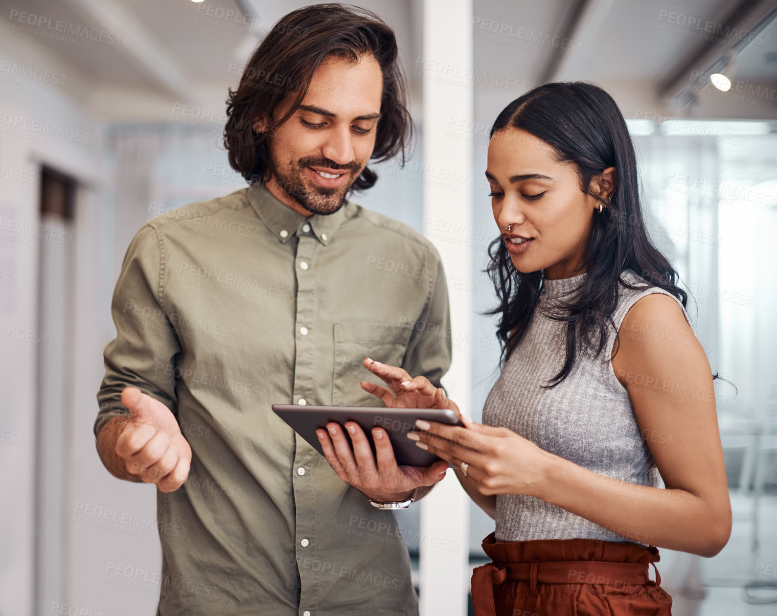 Buy stock photo Shot of two businesspeople using a digital tablet together in an office