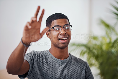 Buy stock photo Shot of a young businessman raising his hand in an office
