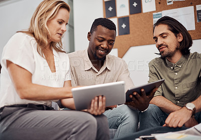 Buy stock photo Shot of a group of businesspeople working together on a digital tablet in an office