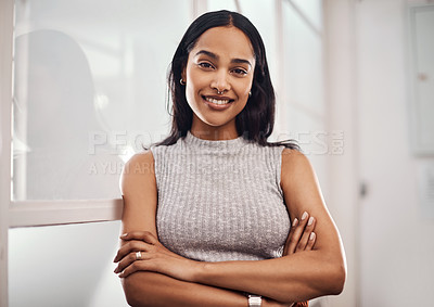 Buy stock photo Portrait of a young businesswoman standing with her arms crossed in an office