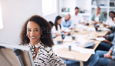 Buy stock photo Portrait of a young businesswoman using a whiteboard while giving a presentation to her colleagues in an office