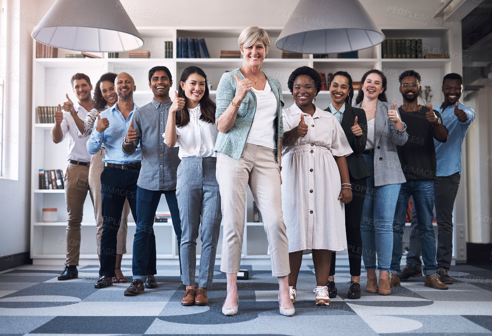 Buy stock photo Portrait of a diverse group of businesspeople showing thumbs up together in an office