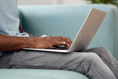 Buy stock photo Cropped shot of an unrecognizable businessman sitting alone and using his laptop in the office