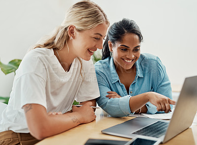 Buy stock photo Cropped shot of two attractive businesswoman sitting together and using a laptop in the office