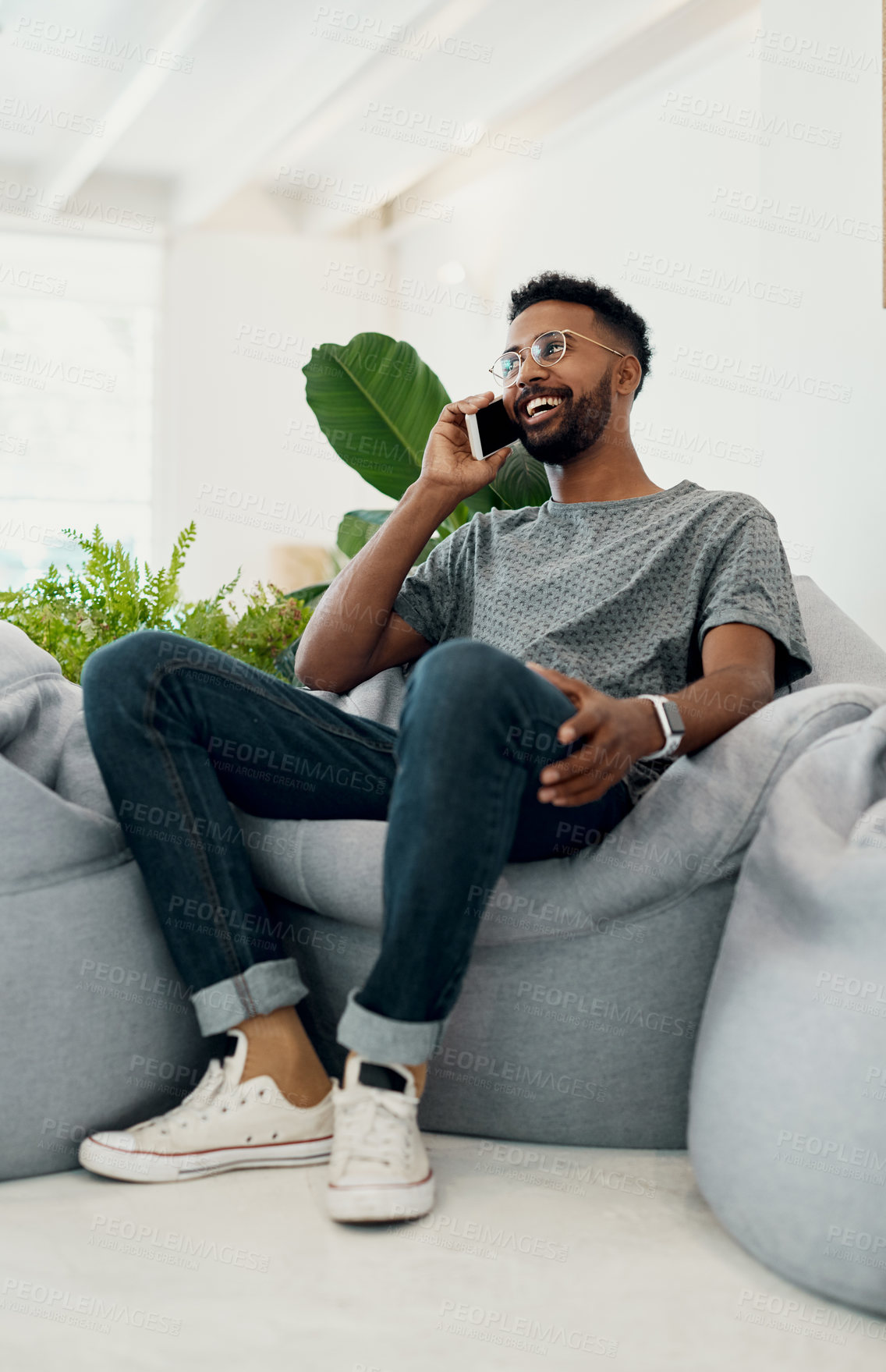 Buy stock photo Man, smile and phone call on bean bag for contact, chat and communication in creative office. Male designer, mobile and talk on furniture for customer service, good news or information in workplace