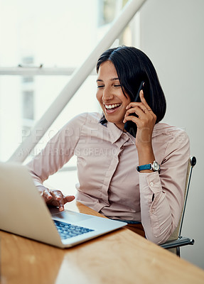 Buy stock photo Cropped shot of an attractive young businesswoman sitting and using her cellphone while working on a laptop in the office