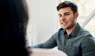 Buy stock photo Cropped shot of a handsome young businessman sitting with a colleague in the office during the day