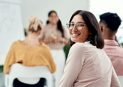 Buy stock photo Cropped portrait of an attractive young businesswoman sitting with her colleagues during a presentation in the office