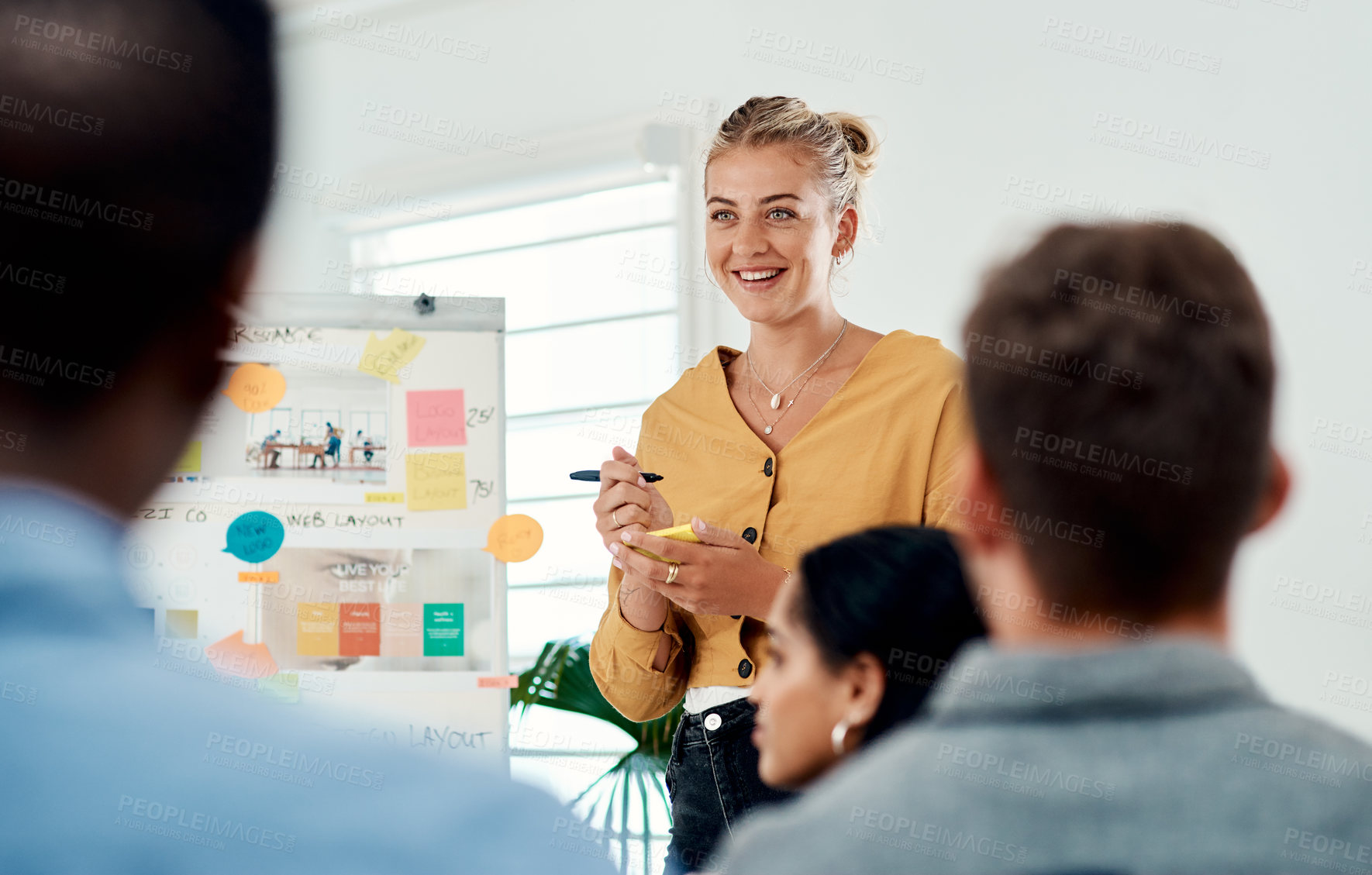 Buy stock photo Cropped shot of an attractive young businesswoman standing and giving a presentation to her colleagues in the office