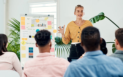 Buy stock photo Cropped shot of an attractive young businesswoman standing and giving a presentation to her colleagues in the office
