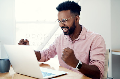 Buy stock photo Cropped shot of a handsome young businessman sitting and alone celebrating while using his laptop in the office