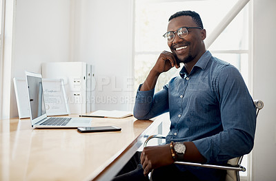 Buy stock photo Cropped portrait of a handsome young businessman sitting alone in his office during the day