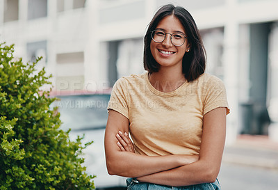 Buy stock photo Cropped portrait of an attractive young businesswoman sitting alone outside with her arms crossed during the day