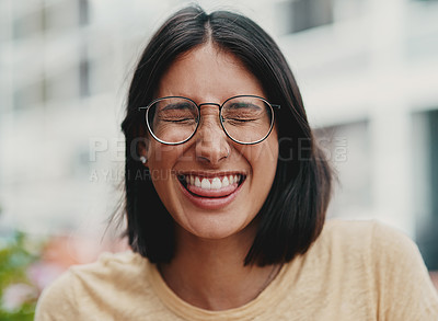 Buy stock photo Cropped shot of an attractive young businesswoman sitting alone outside and feeling playful while making a face