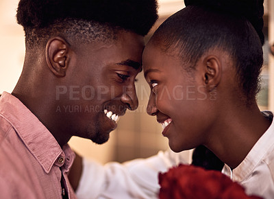 Buy stock photo Cropped shot of an affectionate young couple smiling at each other on Valentine's day at home