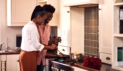 Buy stock photo Cropped shot of an affectionate young couple cooking together on Valentine's day at home