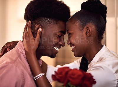 Buy stock photo Cropped shot of an affectionate young couple smiling at each other on Valentine's day at home