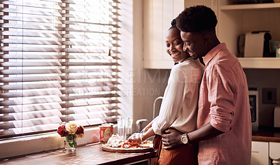 Buy stock photo Cropped shot of an affectionate young man hugging his wife while she's chopping vegetables at home