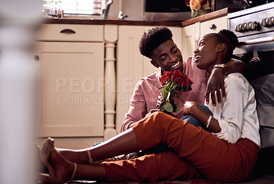Buy stock photo Full length shot of an affectionate young man giving his wife a bunch of roses in their kitchen at home