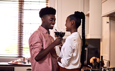 Buy stock photo Cropped shot of an affectionate young couple drinking wine together in their kitchen at home