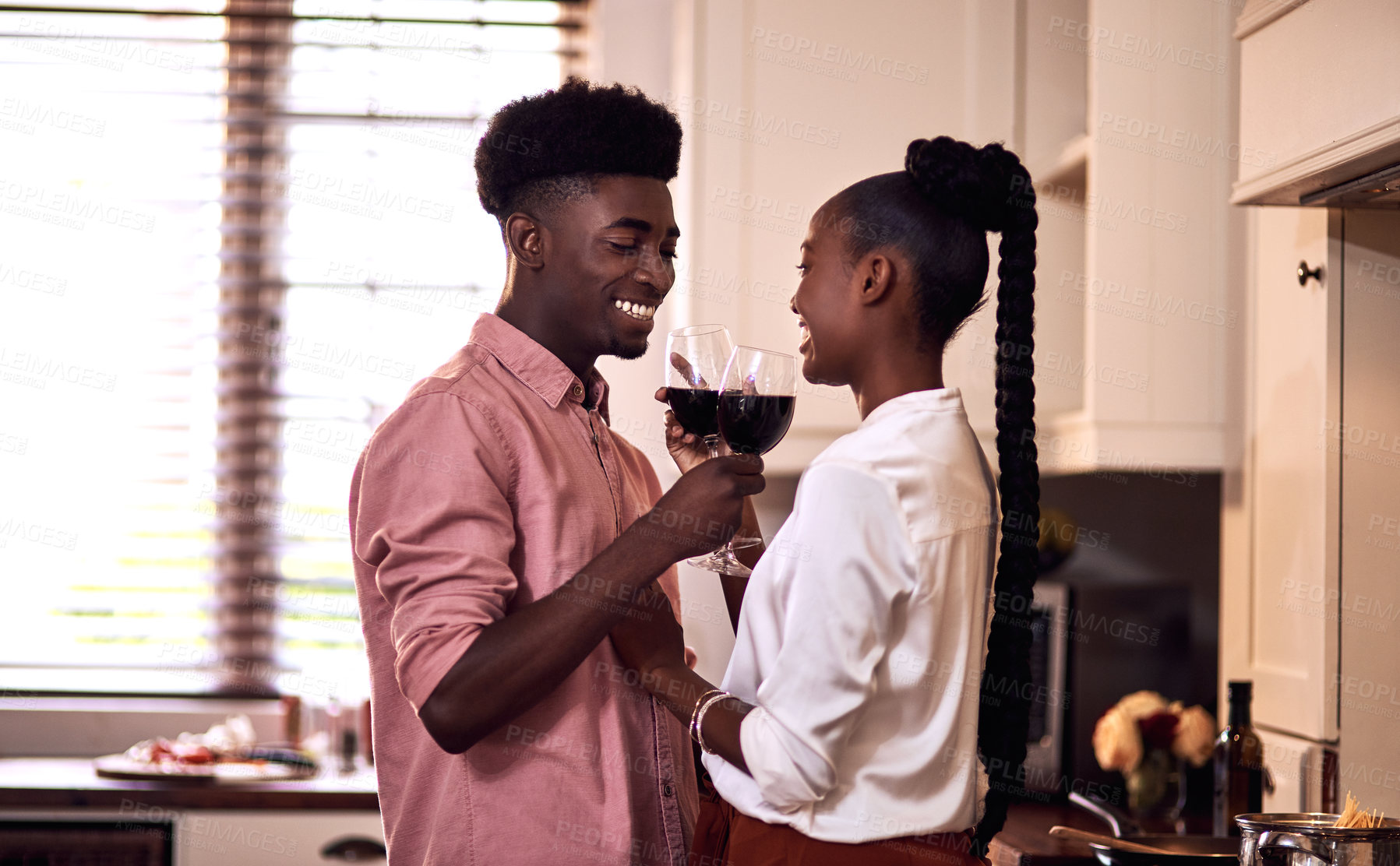 Buy stock photo Black people, couple and happy with wine glass for toast for love, support and bonding with trust. Home, relationship and smile in kitchen with cheers for anniversary celebration, relax and romantic