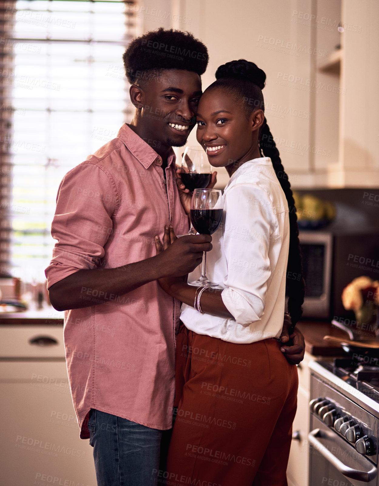 Buy stock photo Cropped portrait of an affectionate young couple smiling while holding wine glasses in their kitchen at home