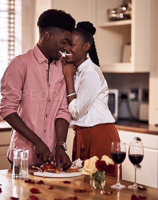 Buy stock photo Cropped shot of an affectionate young couple smiling at each other while cooking together on Valentine's day at home