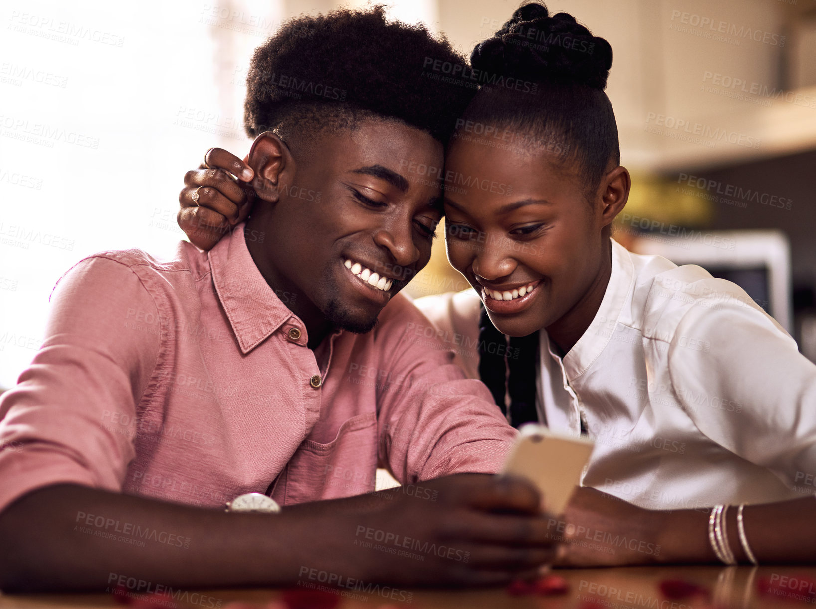 Buy stock photo Cropped shot of an affectionate young couple using a smartphone together on in their kitchen at home